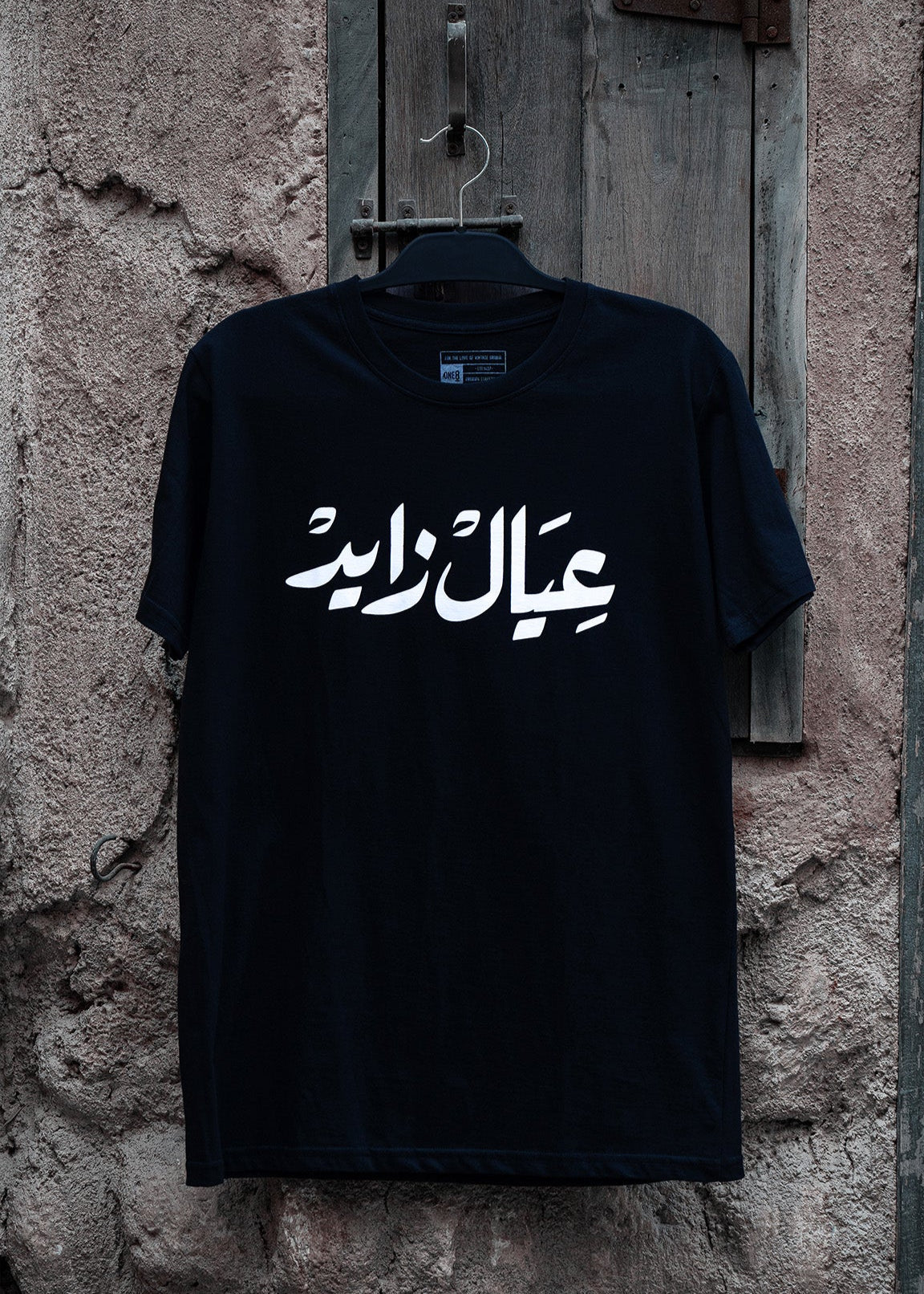 Emirati T-Shirt black unisex T-shirt with bold Arabic calligraphy عيال زايد celebrating the UAE