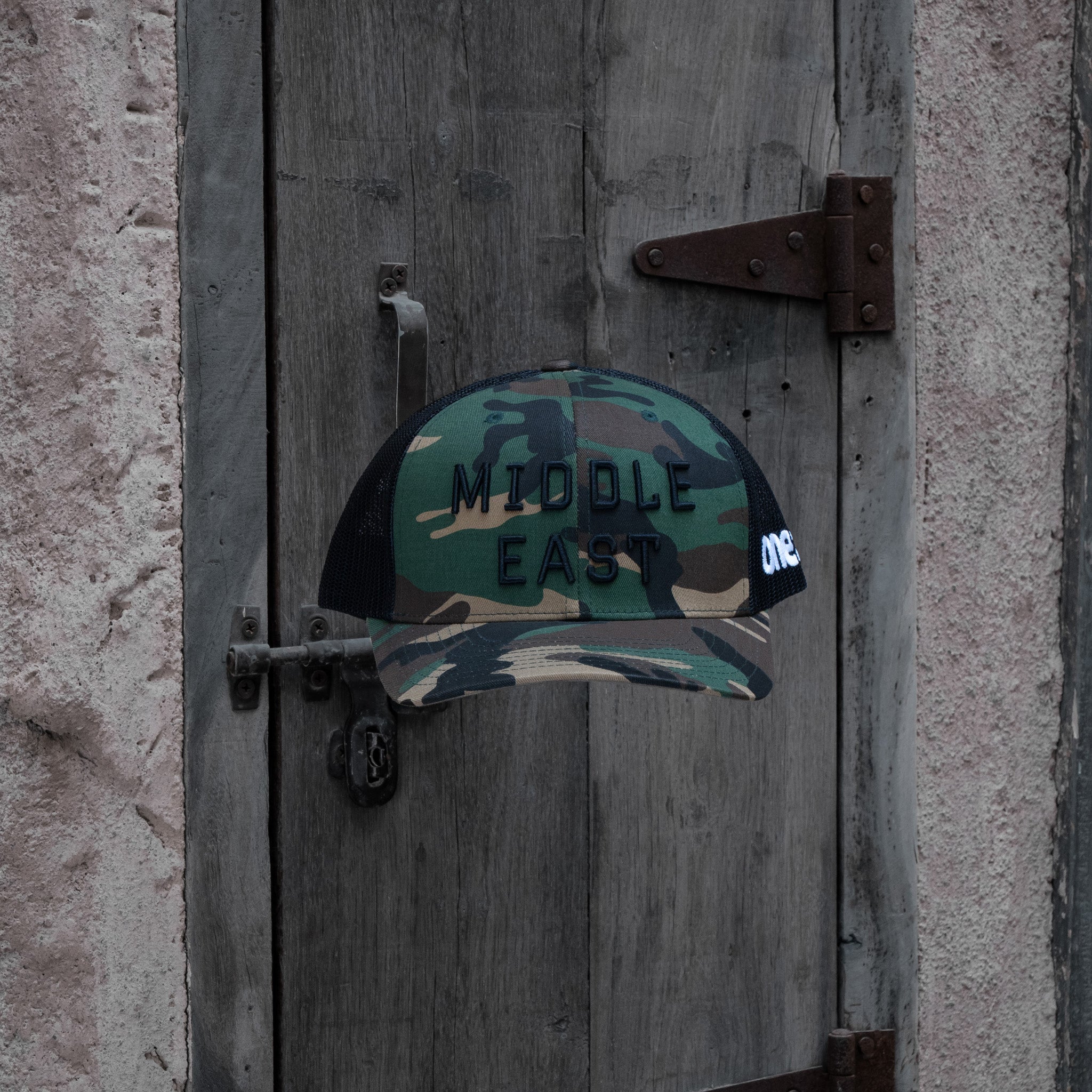 Middle East Trucker One8 Hat: Camo trucker cap with Middle East 3D embroidery lettering stands out 