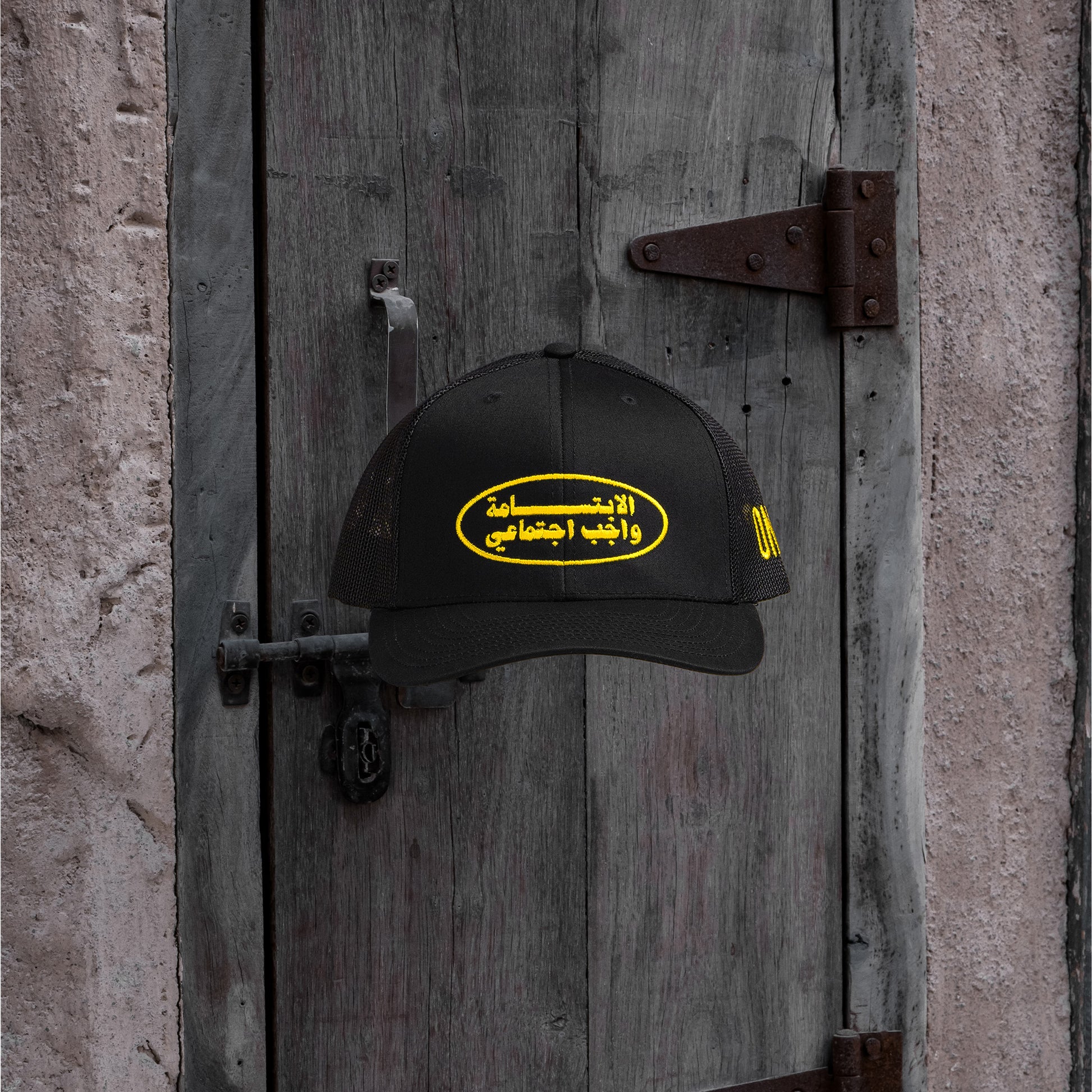 Smile الابتسامة واجب اجتماعي meshback trucker hat with flat Arabic text, One8 cap