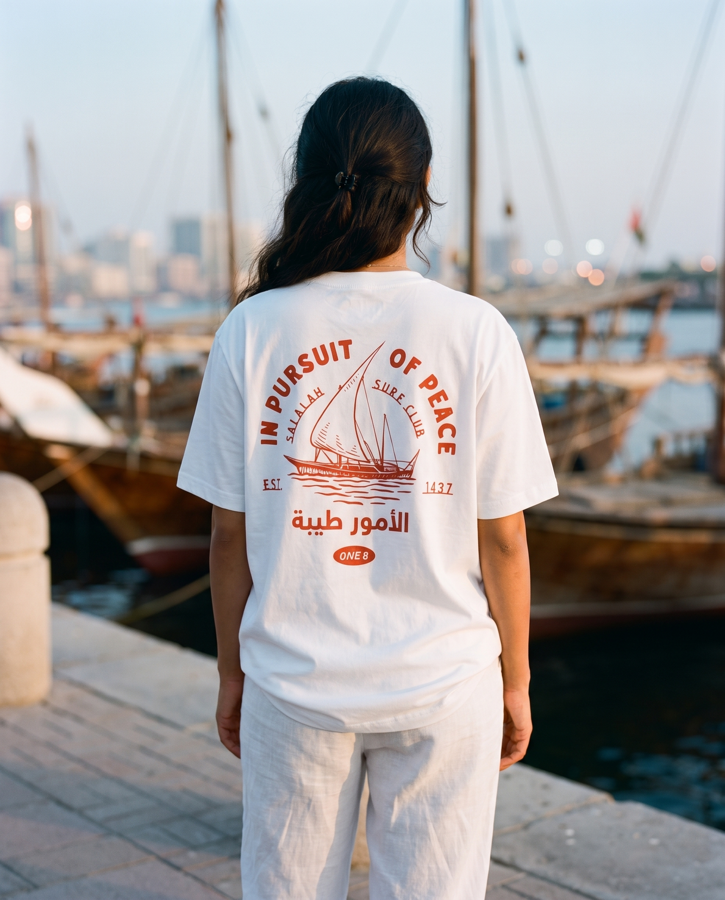 Salalah Surf Club Dhow tee back print worn by female model at Dubai Creek