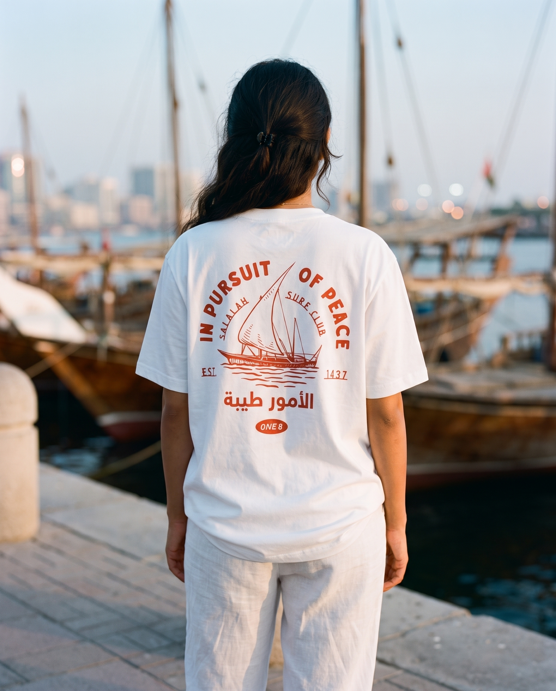 Salalah Surf Club Dhow tee back print worn by female model at Dubai Creek