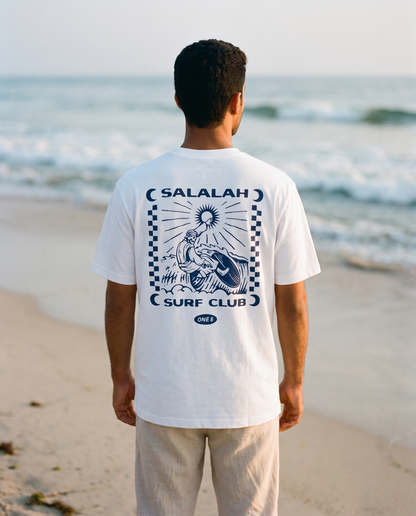 Salalah Surf Club Omani Surfer tee back print worn by male model on the shoreline