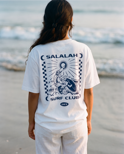 Salalah Surf Club Omani Surfer tee back print worn by female model on the shoreline
