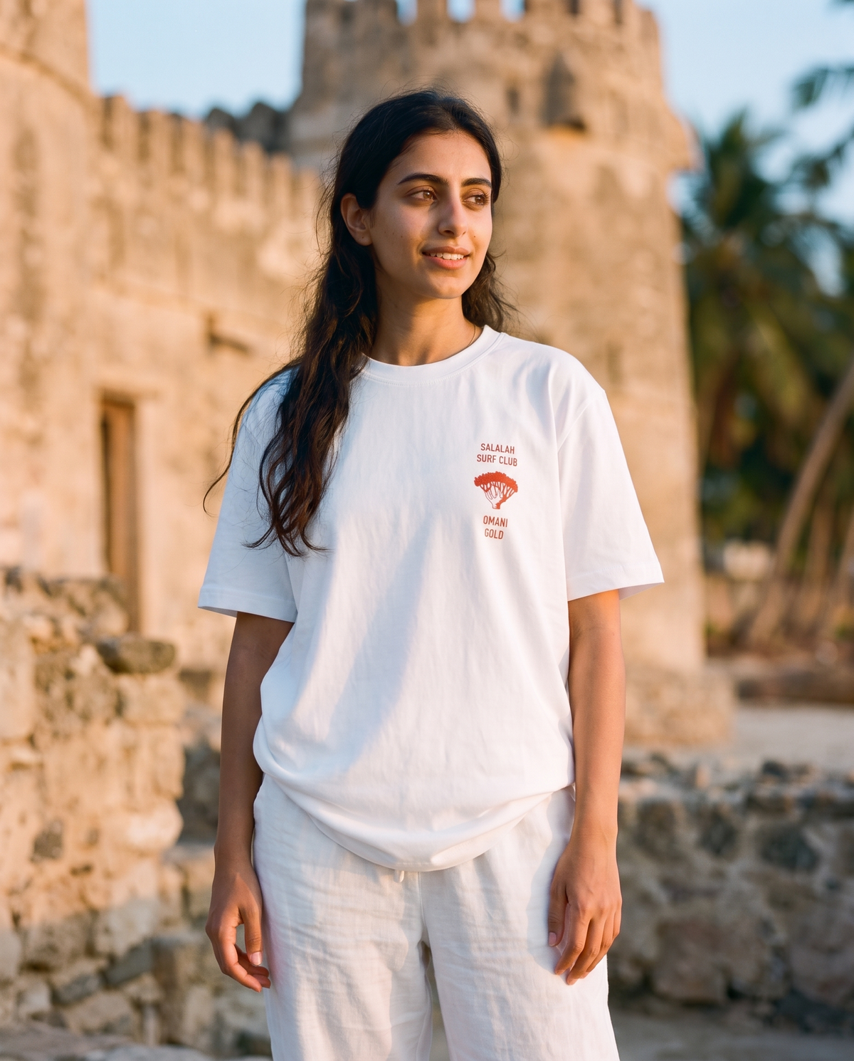 Salalah Surf Club Omani Gold tee front chest print, female model, oversized fit