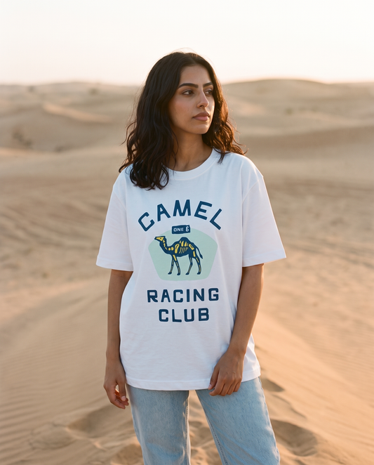 Skeletal Camel Racing Club tee, female model standing on dune crest