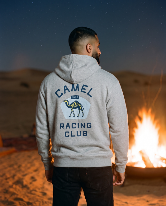 Skeleton camel hoodie Camel Racing Club back print worn by male model at a desert campfire
