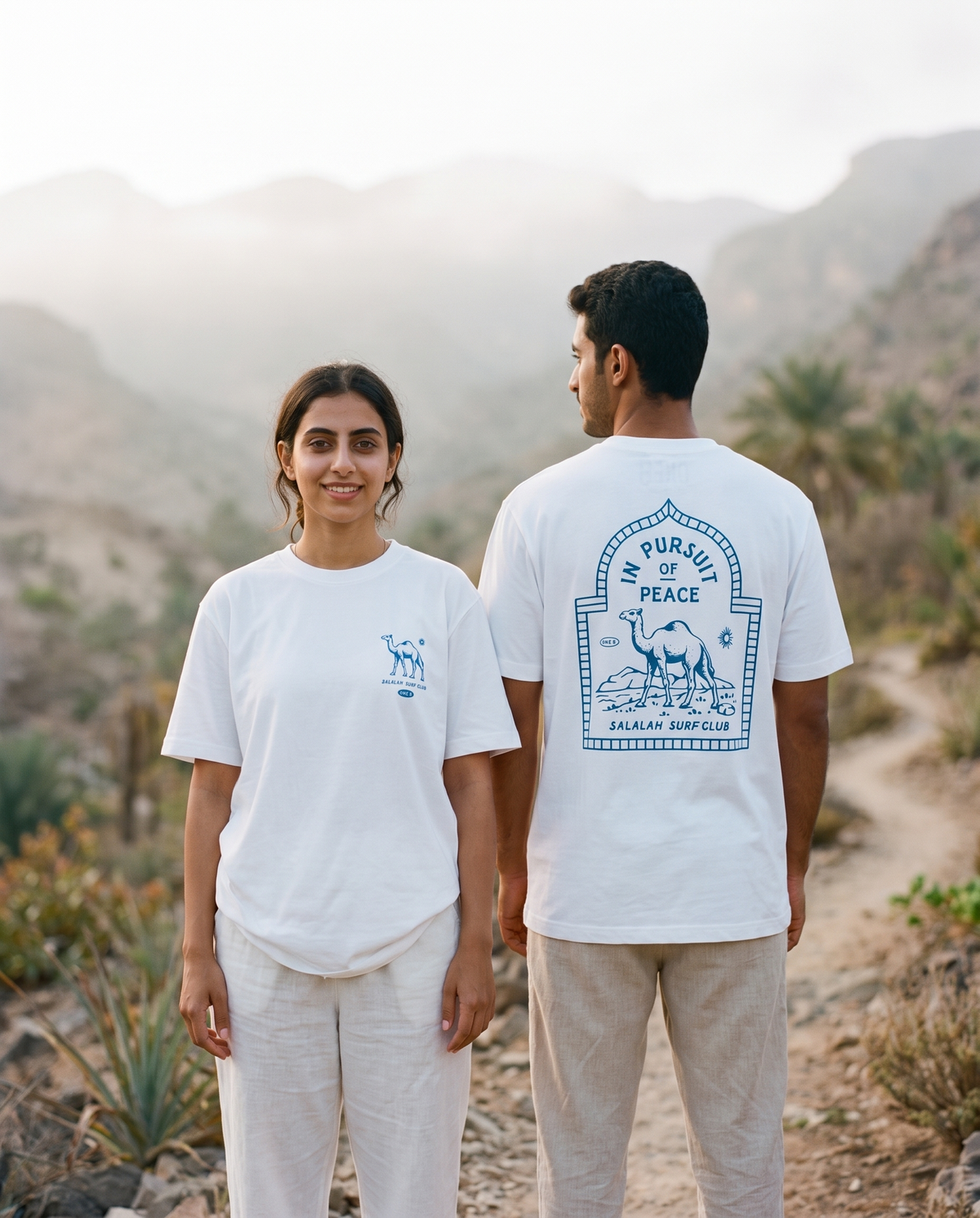 Camel tee worn by male and female models on a misty mountain trail, front and back view