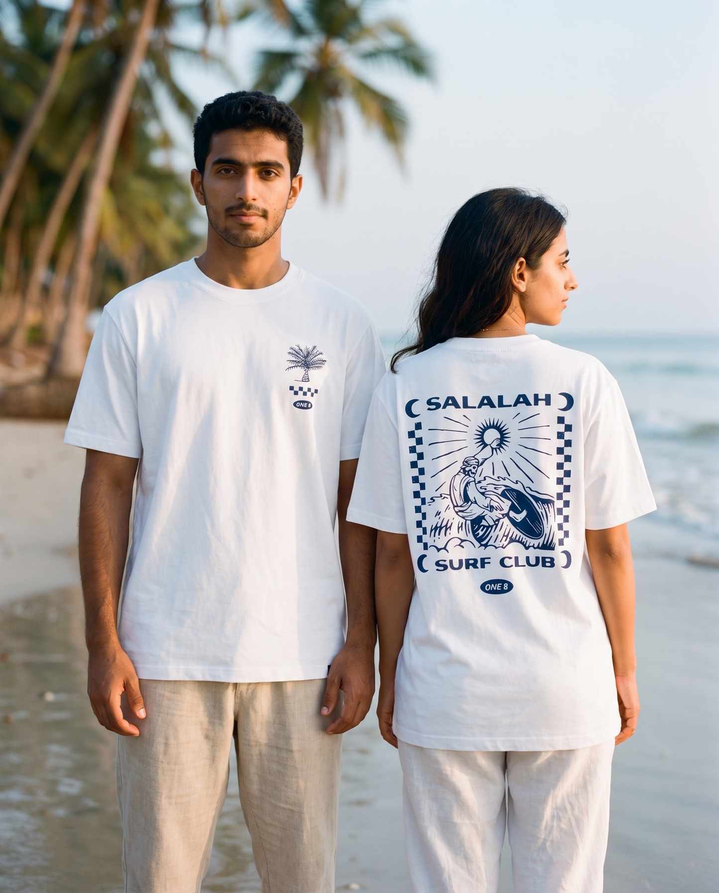 Surfer tee worn by male and female models on the beach, front and back view