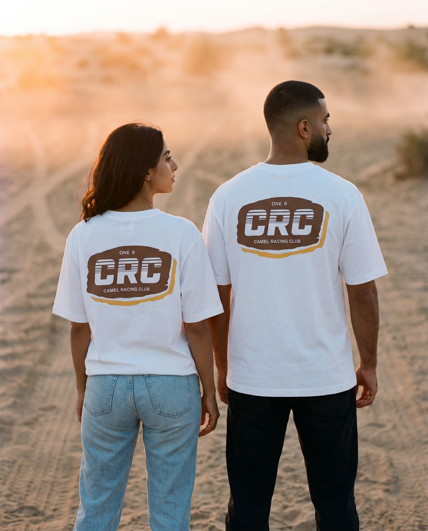 Motocross CRC tee back print worn by male and female models on a desert track at sunset