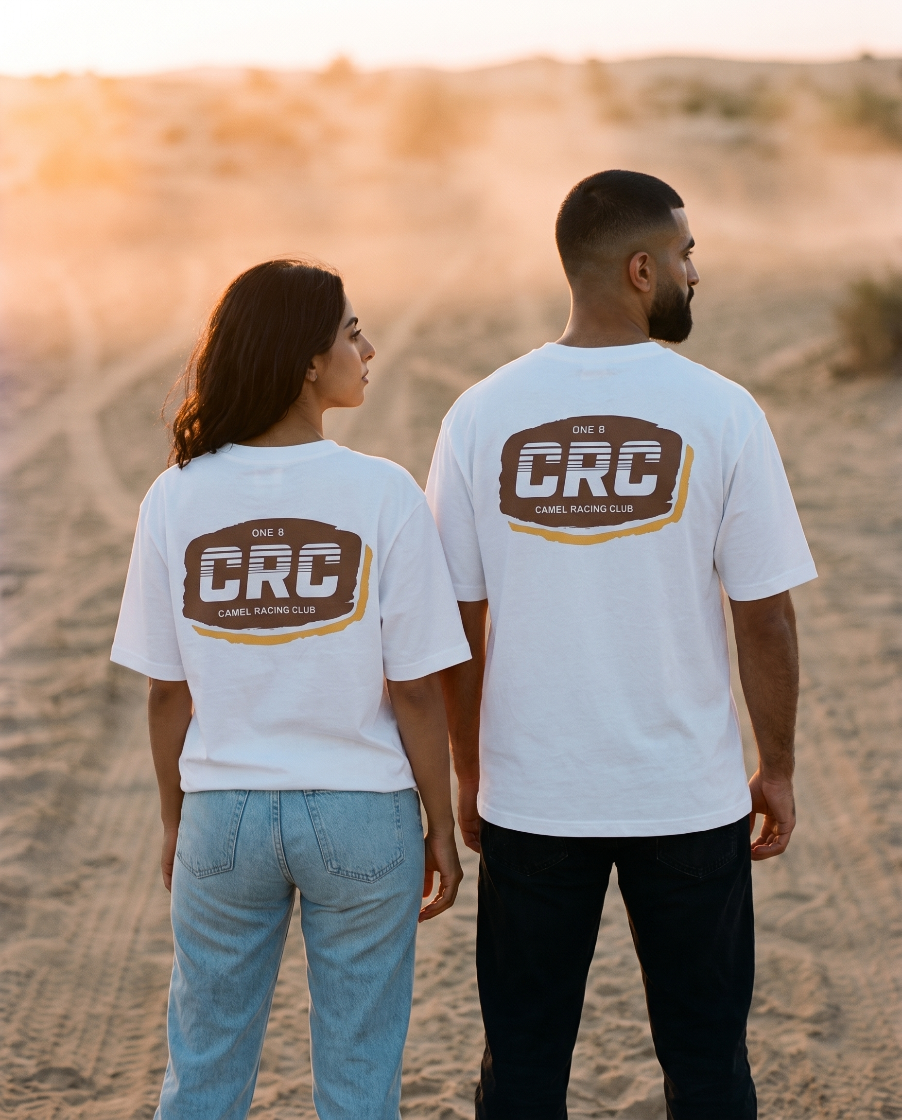 Motocross CRC tee back print worn by male and female models on a desert track at sunset