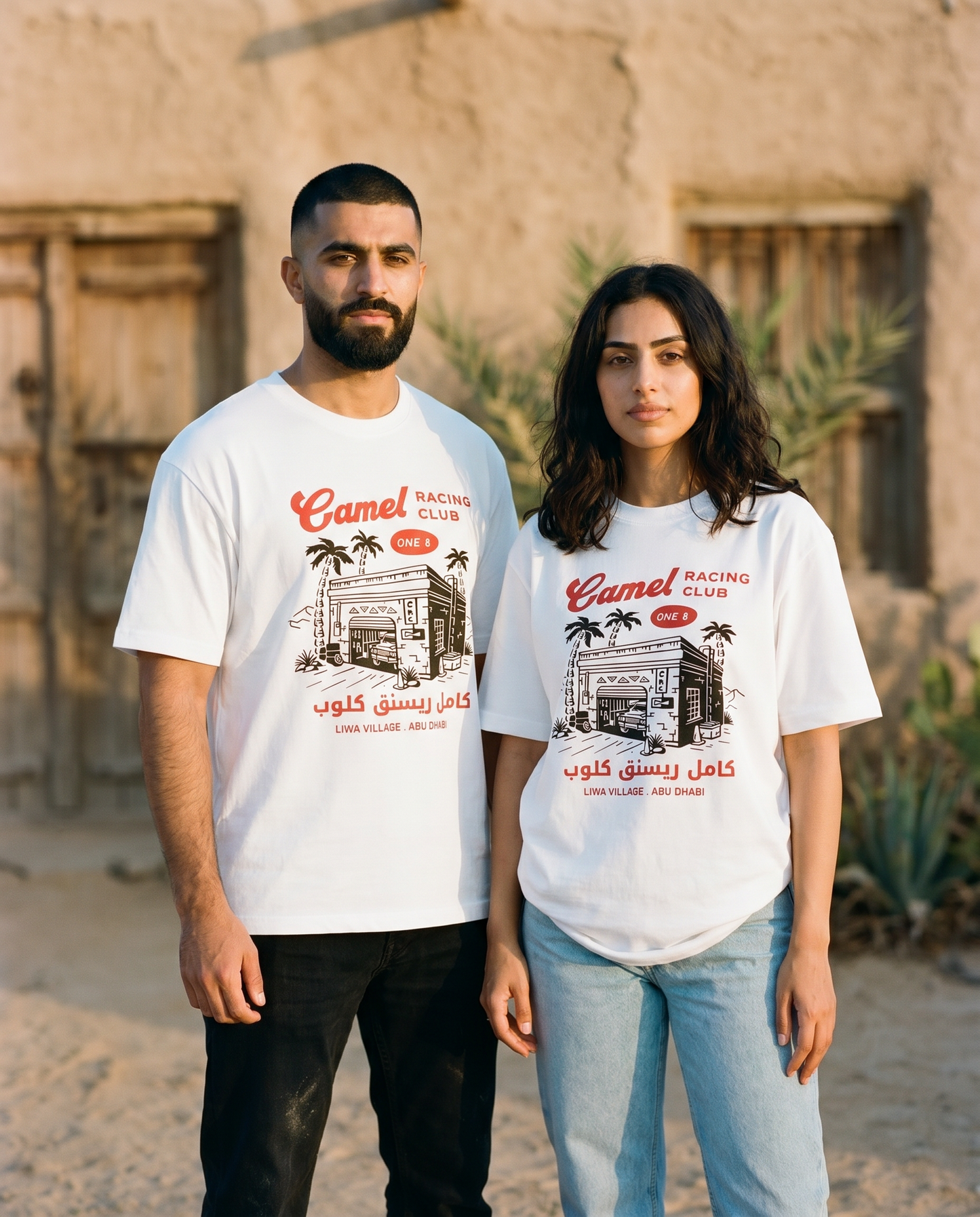 Workshop tee front print worn by male and female models outside a desert village garage