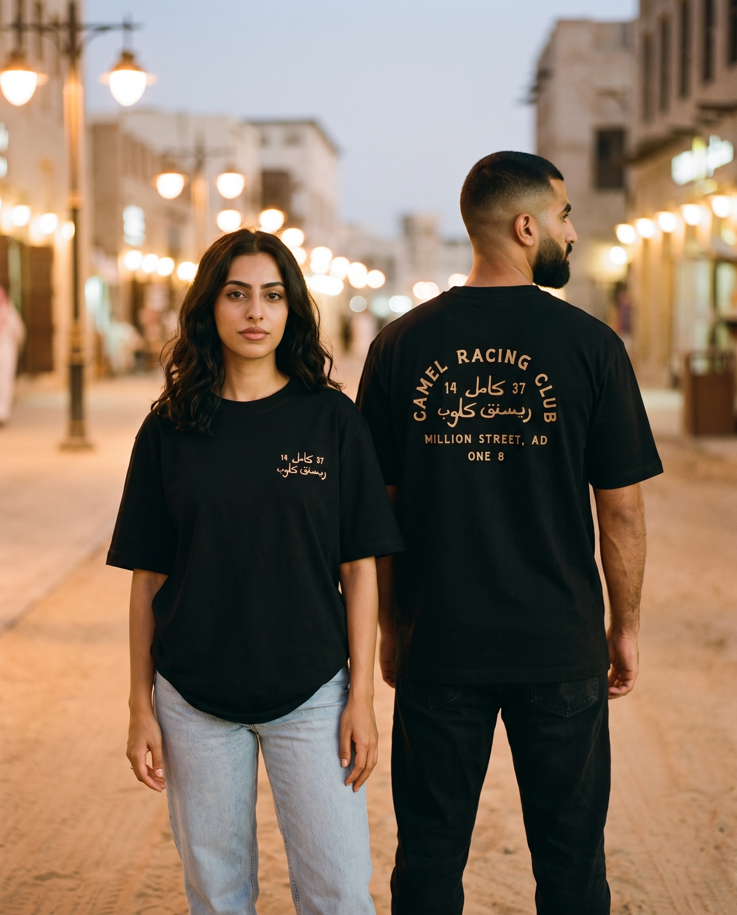 Million Street tee worn by male and female models on a lamplit heritage street, front and back view