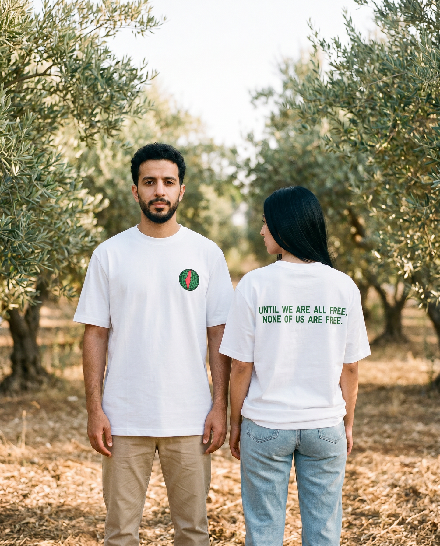 Free Palestine white tee worn by male and female models in an olive grove, front and back view