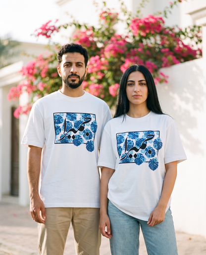 Jumeirah Floral unisex tee worn by male and female models by a Jumeirah villa wall