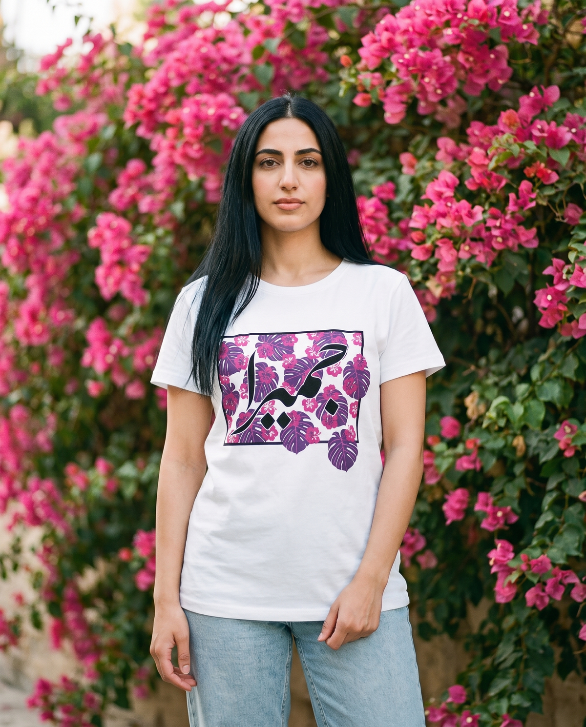 Jumeirah Floral ladies tee purple and pink floral print worn by female model by a bougainvillea wall