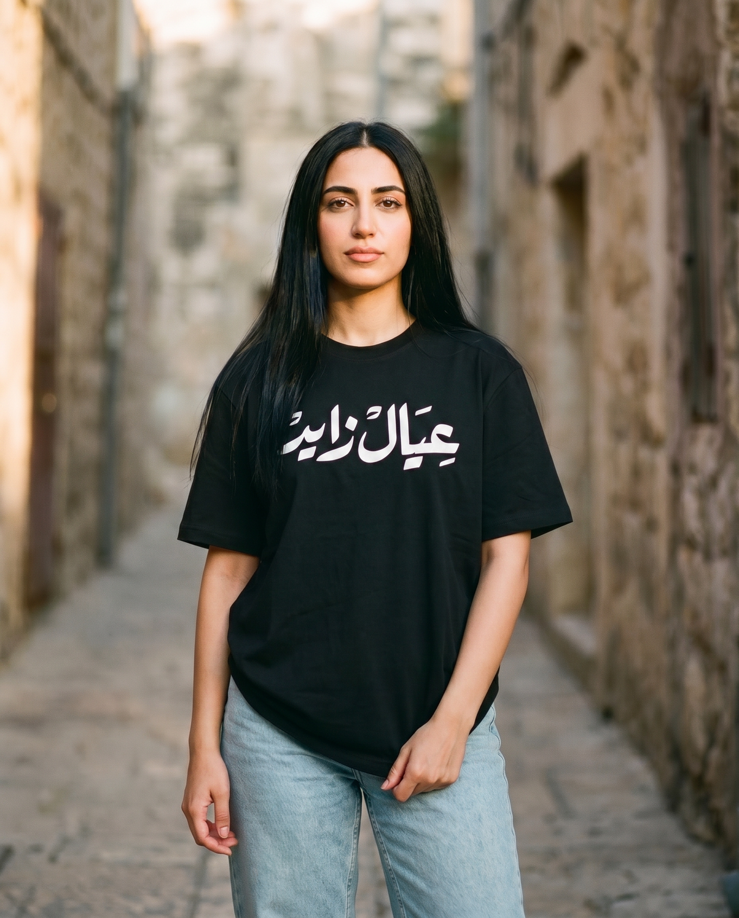 A'yal Zayed unisex tee white Arabic calligraphy worn by female model
