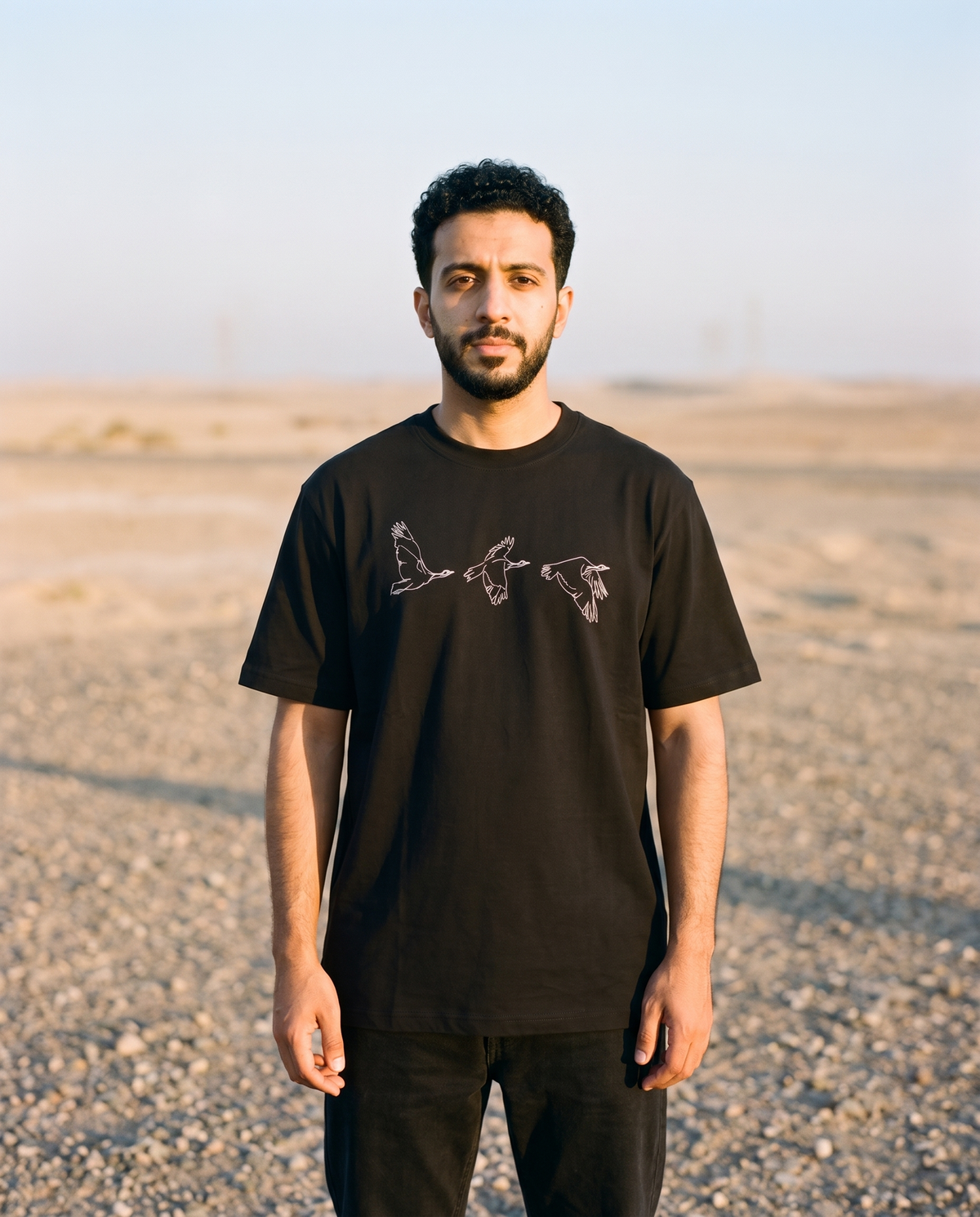 Houbara in Flight tee white bird line print worn by male model