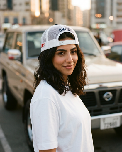 Sitta Wa Khattain trucker hat worn backwards showing ONE8 mesh back, female model with classic Nissan Patrol