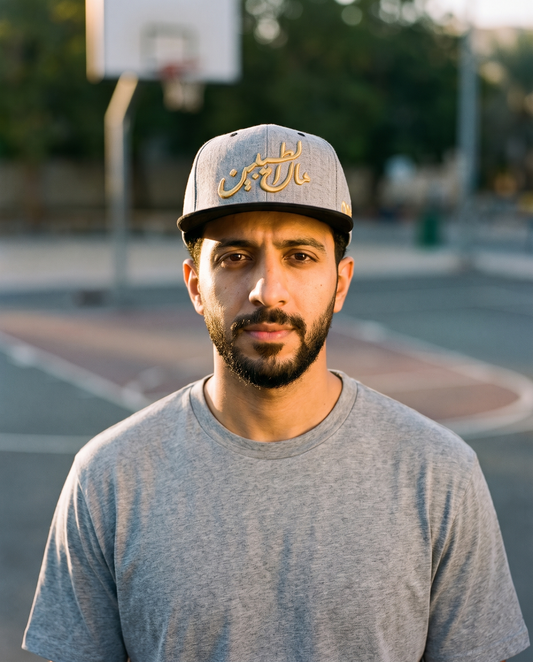 Mal Al Tayyebeen grey flat brim snapback worn frontwards by male model at a basketball court