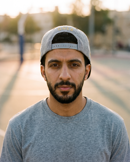 Mal Al Tayyebeen snapback worn backwards showing ONE8 back at golden hour court