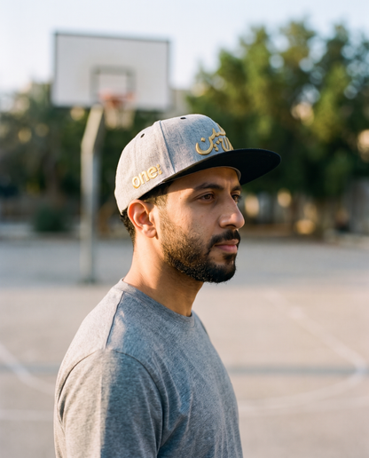 Mal Al Tayyebeen snapback side profile with gold one8 logo at basketball court