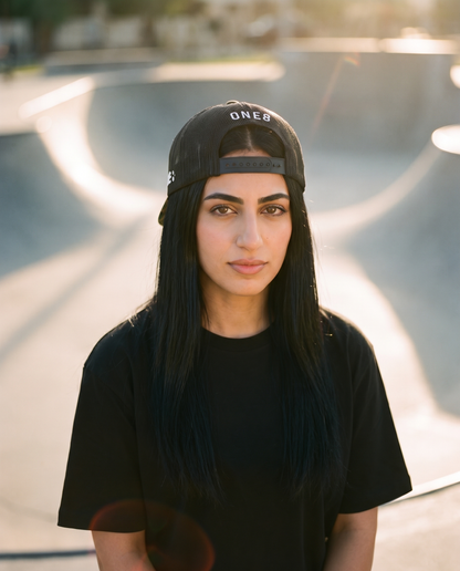 Middle East camo trucker worn backwards showing ONE8 mesh back at the skate park